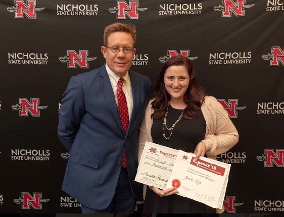 Our NSU President, Dr. Jay Clune, bestowing a small award and posing with Sarah.